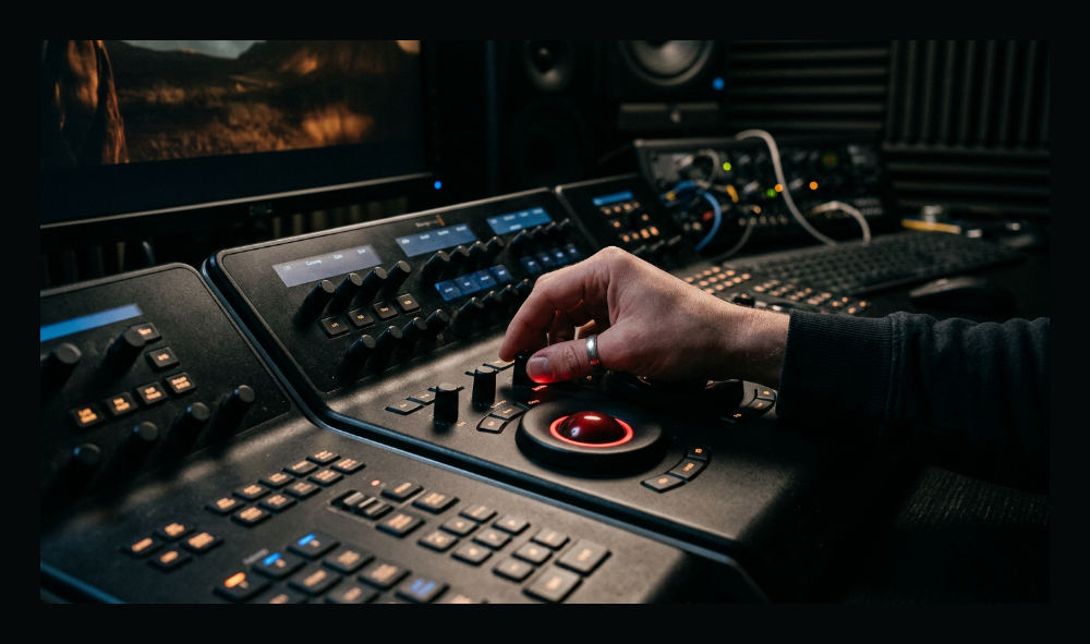 A video professional performing professional color grading services using a control surface.